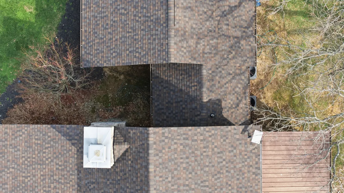Overhead view of a finished architectural shingle roof with a chimney